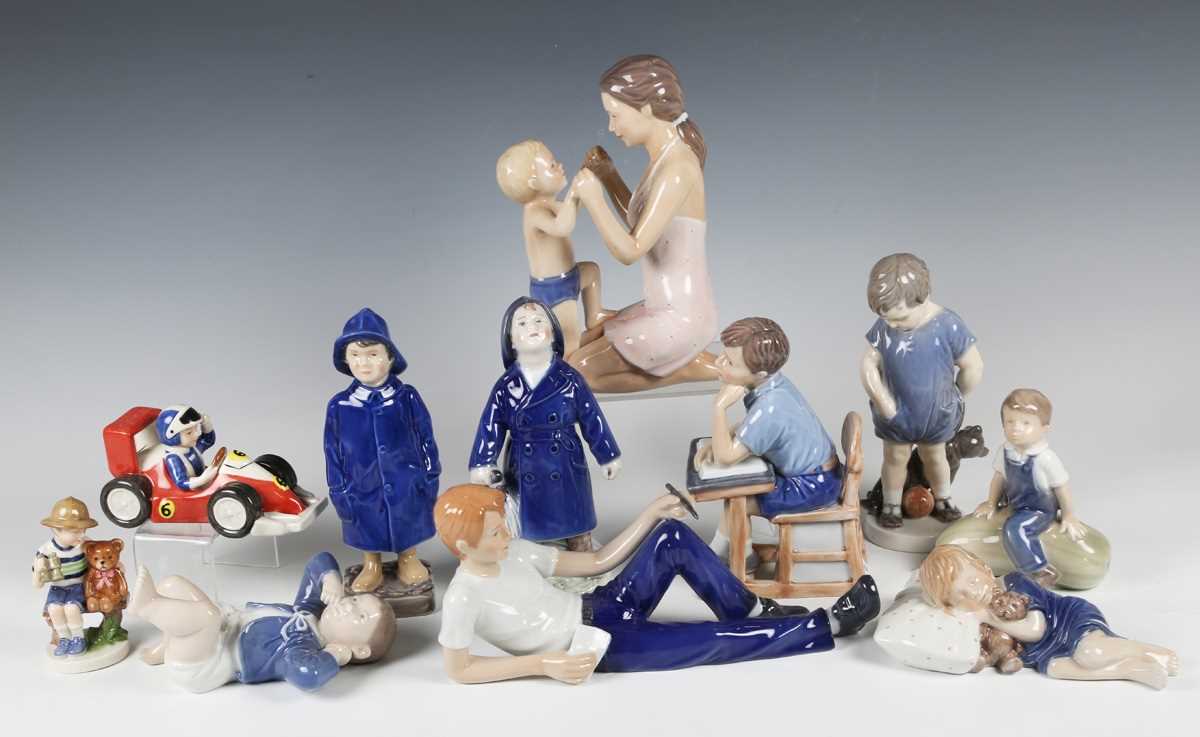Eleven assorted Royal Copenhagen figures, including two boys in raincoats, a reclining man with