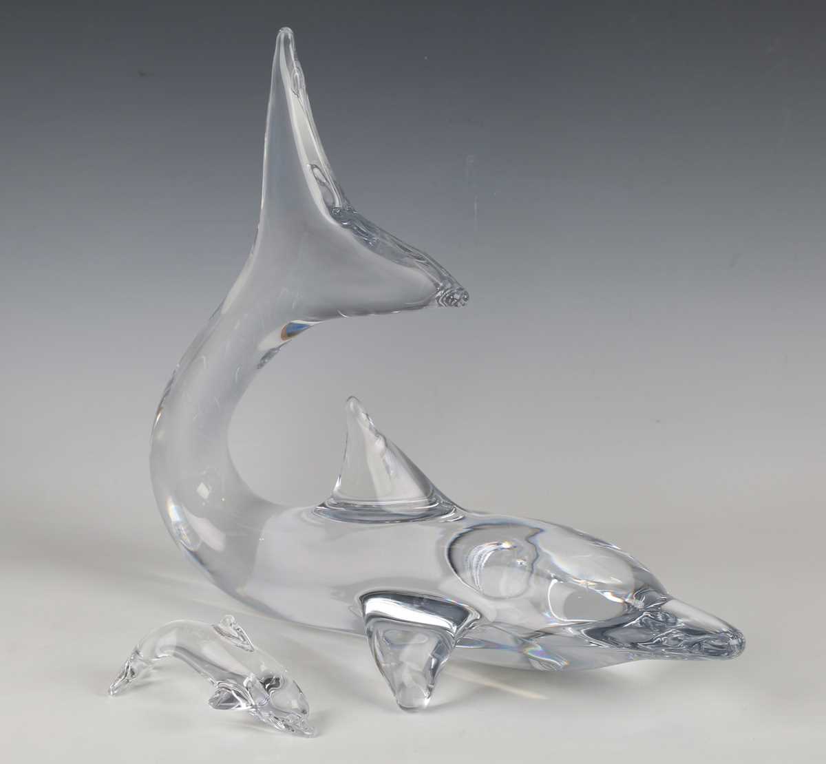 A large Daum clear glass model of a dolphin, contemporary, its tail raised, engraved 'Daum France'