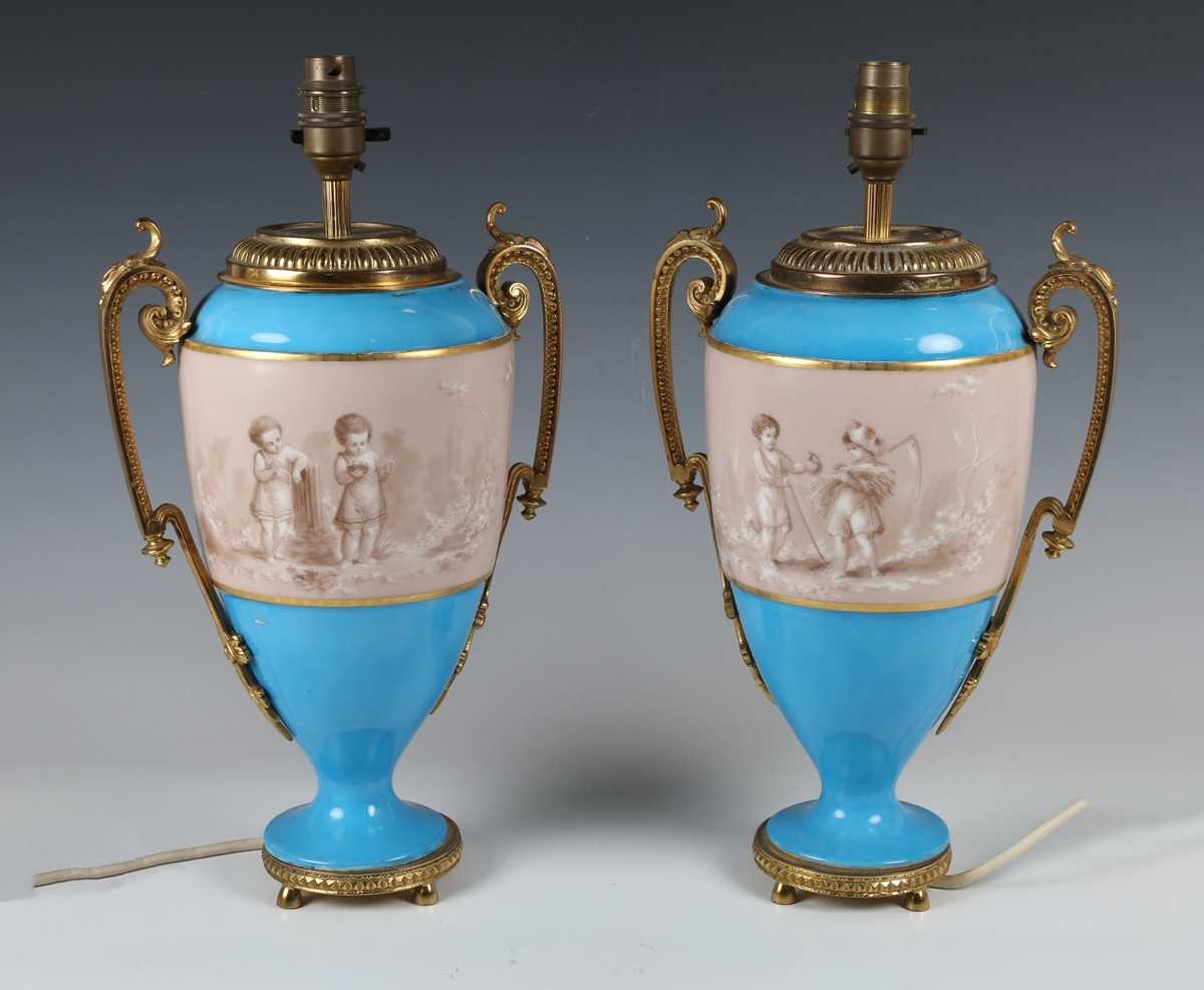 A pair of Sèvres style ormolu mounted porcelain lampbases, circa 1900, both painted with a sepia