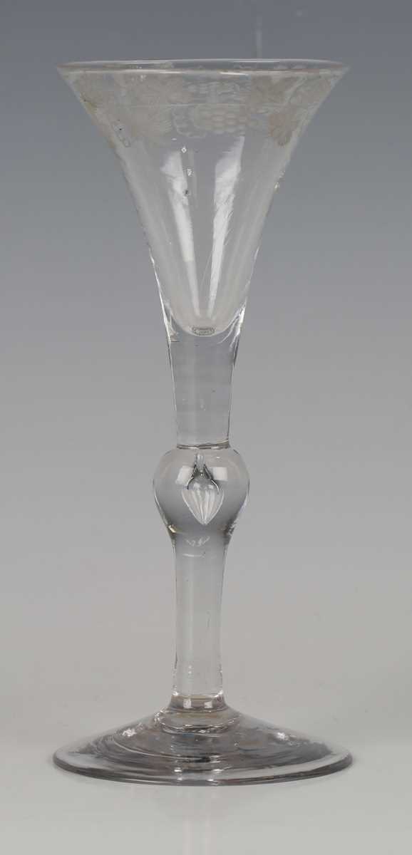 An engraved Kit Kat type wine glass, circa 1730, the drawn trumpet bowl with a band of fruiting vine