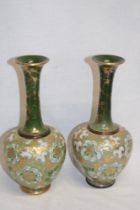 A pair of Royal Doulton pottery tapered spill vases with cream and gold decoration on green ground