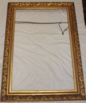 A large Victorian gilt rectangular picture frame with raised scroll decoration,