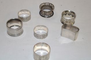 Seven various silver napkin rings with engraved and raised decoration