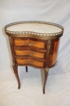 A reproduction French inlaid mahogany kidney-shaped centre chest of three small curved drawers