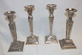Two pairs of silver plated classical-style candlesticks with raised decoration on square bases 9