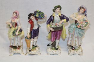 Two pairs of German china figures of a male and female with baskets of flowers and male and female