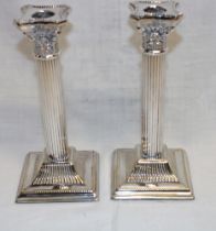 A pair of good quality silver-plated Corinthian column candlesticks with fluted stems and square