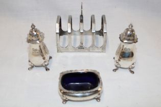 A small silver four-section toast rack with loop handle,