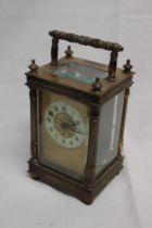 A French carriage clock with circular decorated dial in brass traditional glazed case with fluted