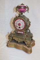 A French brass mantel clock with porcelain circular dial in relief decorated tapered case 11" high