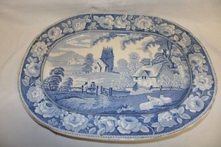 A Victorian Staffordshire pottery oval meat platter with blue and white country and church scene