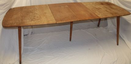 A 1960s Ercol pale elm rectangular extending dining table with two additional folding centre leaves