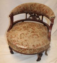 A Victorian walnut tub-style easy chair with curved back and upholstered seat on turned legs with