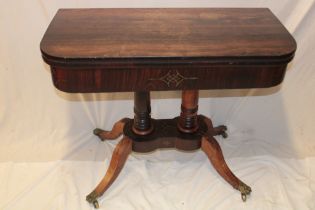 An early 19th century rosewood rectangular turn-over-top card table with brass inlaid frieze on