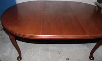 An Edwardian mahogany oval dining table on cabriole legs,