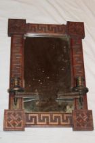 A late Victorian carved mahogany rectangular wall mirror with attached brass adjusting candle