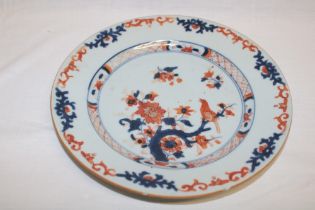 An early 19th century Chinese circular plate with blue and red painted floral decoration