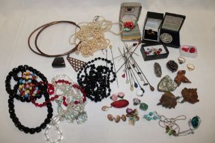 A large selection of various costume jewellery including necklaces, brooches, stick-pins, earrings,