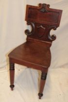 A Victorian carved mahogany hall chair with decorative rectangular back on turned tapered legs