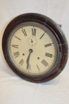 An old school-style wall clock with painted circular dial in stained wood circular case,