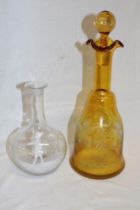 A 1930's amber tinted glass tapered decanter with vine leaf and grape decoration and one other