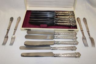 A cased set of six German silver-plated table knives with relief silver mounted handles and a