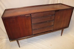 A 1960's teak sideboard with four central drawers flanked by cupboards enclosed by two panelled