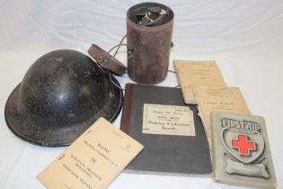 A Second War British steel helmet, gas mask in canister, Cadet's training manuals,