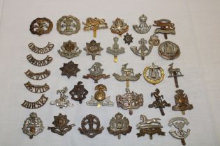 A selection of approximately 30 various military cap badges including the Worcester Regiment,