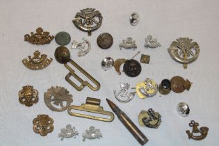 A selection of DCLI Military badges, shoulder titles, DCLI plastic cap badge,