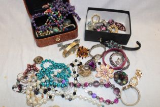 Two boxes containing a quantity of various costume jewellery including necklaces, brooches,