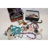 Two boxes containing a quantity of various costume jewellery including necklaces, brooches,