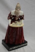A Czechoslovakian pottery advertising figure depicting a serving maid with tray supporting three
