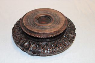 An Eastern carved wood circular vase stand with pierced decoration,