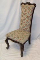 A Victorian mahogany prayer-style chair upholstered in floral tapestry on scroll-shaped legs