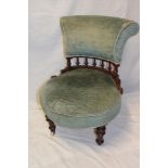A Victorian mahogany easy chair with upholstered seat and back on turned legs with castors