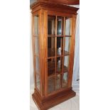 A reproduction mahogany full length display cabinet with mirror back and shelves enclosed by a
