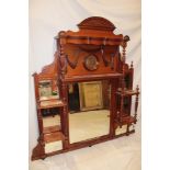 A Victorian walnut overmantel mirror with rectangular and square panels flanked by open shelves on