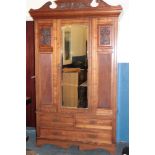 A Victorian walnut wardrobe with hanging compartment enclosed by a central mirror panel door above