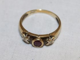 An old gold gypsy-style dress ring set a red stone flanked by two diamond chips (1.