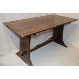 A rustic carved oak rectangular refectory dining table, the ends with floral emblems,