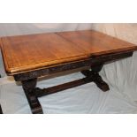 A 1930's oak rectangular draw-leaf refectory-style table with decorated frieze on carved supports