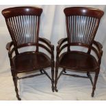 A pair of figured mahogany occasional chairs with rail backs and polished shaped seats on turned