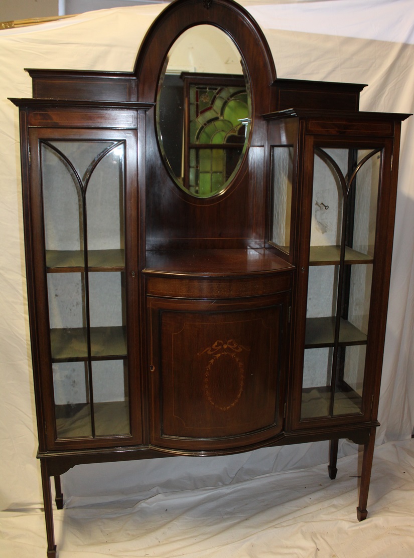 A late Victorian inlaid mahogany display cabinet with central bevelled oval mirror and cupboard
