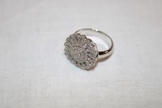 An 18ct white gold dress ring with circular mount set numerous small diamonds (5.