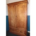 A 19th century satinwood gents wardrobe with sliding trays enclosed by two arched panelled doors