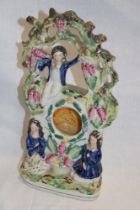 A Victorian Staffordshire pottery pocket watch stand depicting three children in a fruiting tree