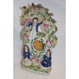 A Victorian Staffordshire pottery pocket watch stand depicting three children in a fruiting tree