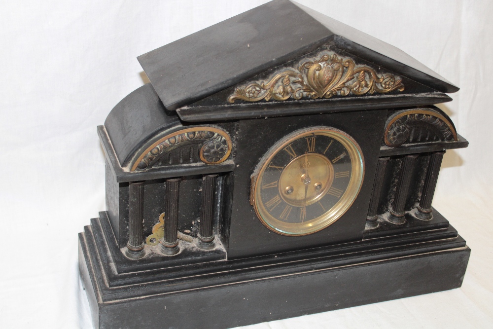 A Victorian mantel clock with decorated circular dial in black slate Venetian-style case