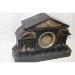 A Victorian mantel clock with decorated circular dial in black slate Venetian-style case